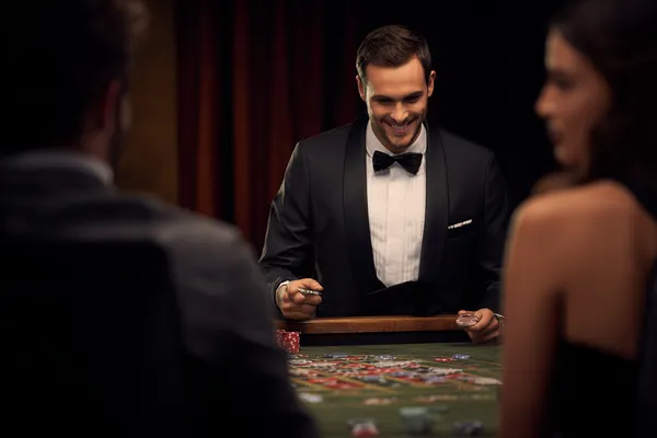 ILOTBED — A high-class gaming experience without limits A woman in a luxurious green gown next to an ornate roulette wheel, capturing the upscale casino mood of ILOTBED.